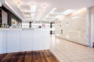 a lobby with a white counter and a brick wall at Reef Resort Villas Port Douglas in Port Douglas +98 photos