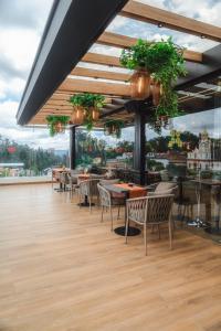 a restaurant with tables and chairs and a large window at Saya Hotel & Suites in Cuenca