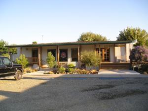 a house with a car parked in front of it at Lake Minden Camping Resort Cottage 2 in Nicolaus