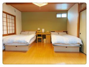 a room with two beds and a desk in it at Hao Bros. Home 和(WA) in Tokyo +15 photos