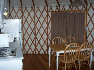 a kitchen with a table and chairs and a refrigerator at Lake of the Springs Camping Resort Yurt 1 in Oregon House