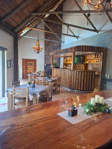 a dining room with wooden tables and chairs at Villa Caramia Guest Lodge in Jan Kempdorp
