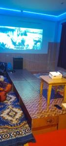 a stage with a table and a large screen at Onarc guest house in Kasol