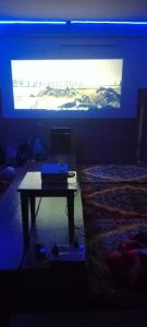 a room with a tv and a table in front of a bed at Onarc guest house in Kasol +4 photos