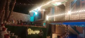 a restaurant with a stage with a sign and lights at Onarc guest house in Kasol