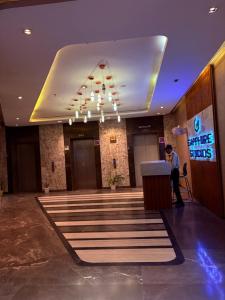 a man standing at a podium in a hotel lobby at Hotel Namaste With Jacuzzi I Best For Couples and Corporate I Noida in Noida