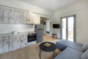 a kitchen and living room with a couch and a table at DION APARTMENTS in Paleros