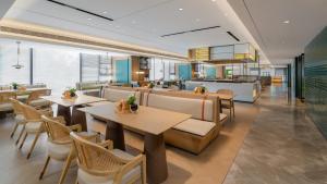 a restaurant with tables and chairs and a kitchen at EVEN Hotel Xi'an High-Tech Zone by IHG in Xi'an