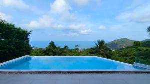 a swimming pool with a view of the ocean at Villa Lumina, Koh Samui in Chaweng Noi Beach