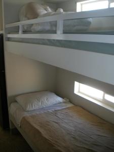 two bunk beds in a room with a bed at Palm Springs Camping Resort Cottage 1 in Palm Desert