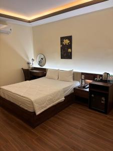 a bedroom with a bed and a desk at Khách Sạn Phượng Vĩ in Cà Mau