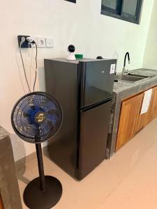 a kitchen with a fan next to a refrigerator at Verdana Jungle Retreat Ubud in Ubud