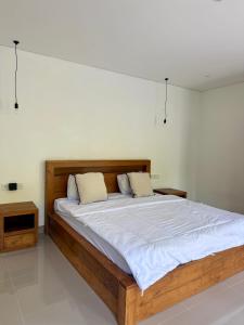 a bedroom with a large wooden bed with two pillows at Verdana Jungle Retreat Ubud in Ubud