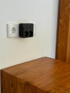 a room with a wooden table with a speaker on a wall at Verdana Jungle Retreat Ubud in Ubud