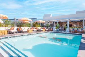a pool at a hotel with chairs and umbrellas at The Shay, a Destination by Hyatt in Los Angeles