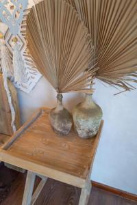 two vases sitting on a wooden table with a fan at Art Cabin Beach Villa in Langstrand