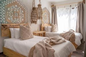 a bedroom with two beds and a window at Art Cabin Beach Villa in Langstrand