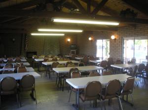 an empty room with tables and chairs and windows at Palm Springs Camping Resort Cabin 3 in Palm Desert