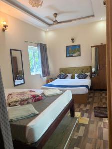 a hotel room with two beds and a window at Serenity Beach House in Pondicherry +5 photos