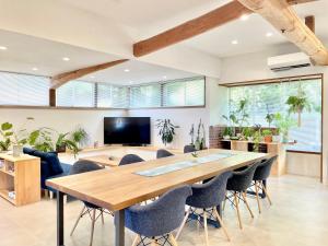 a dining room with a large wooden table and chairs at SEABASE villa at shimane in Matsue