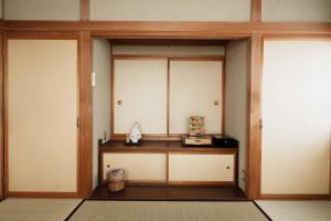 a room with two doors and a table with a box at ゲストハウス豆まめ - Guesthouse Mamemame in Matsumoto