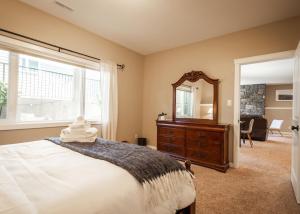 a bedroom with a bed and a mirror and a dresser at Opulent Oasis in Lethbridge
