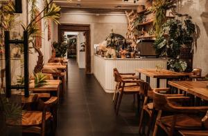 a restaurant with wooden tables and chairs and a bar at Beanstay hostel in Phuket