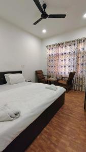 a bedroom with a large bed with a ceiling fan at Himalayan Haven in Srinagar