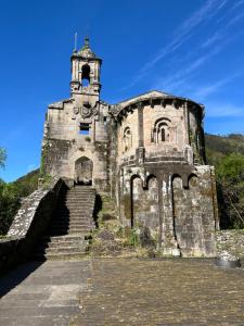 an old stone building with stairs and a bell tower at Alcacer 4-1 in Puentedeume