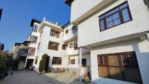 a large white building with windows on a street at Himalayan Haven in Srinagar