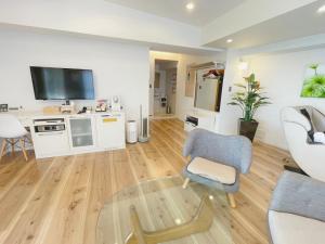 a living room with a tv and a chair and a table at BREATH HOTEL in Fujisawa