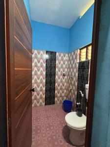 a bathroom with a toilet and a brown door at CK Enclave in Jāmb