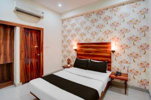 a bedroom with a bed and a wall with flowers at Super OYO Hotel O Khargapur Ring Road Formerly Shimla Grand in Lucknow