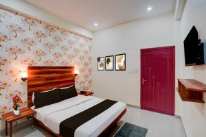 a bedroom with a bed and a red door at Super OYO Hotel O Khargapur Ring Road Formerly Shimla Grand in Lucknow +23 photos