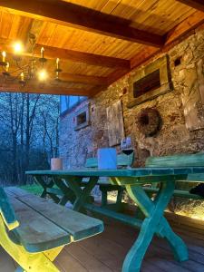a picnic table on a deck with a stone wall at Nasze Chabazie in Olszyna