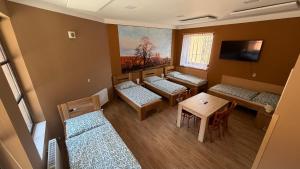 a room with four beds and a table and chairs at Penzion Florian in Moldava