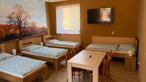 a room with three beds and a table and a tv at Penzion Florian in Moldava +39 photos