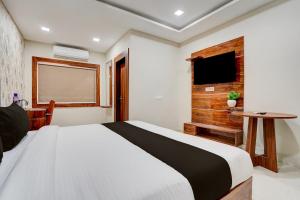 a bedroom with a large bed and a table at Super Collection O AIIMS Bhubaneshwar in Khandagiri