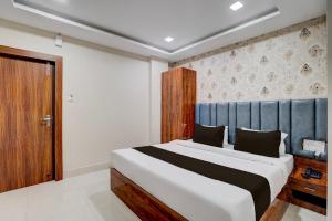 a bedroom with a large bed with a blue headboard at Super Collection O AIIMS Bhubaneshwar in Khandagiri +37 photos