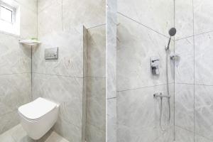 a white bathroom with a shower and a toilet at Super Collection O AIIMS Bhubaneshwar in Khandagiri