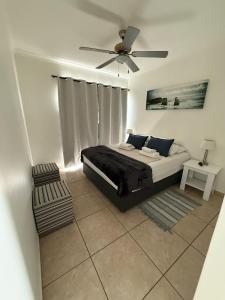 a bedroom with a bed and a ceiling fan at Tide's End in Langstrand