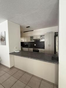 a large kitchen with white cabinets and a counter top at Tide's End in Langstrand