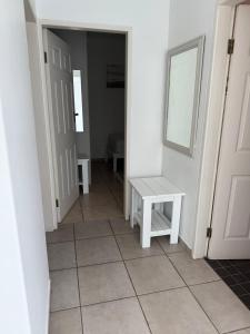 a hallway with a white bench and a door at Tide's End in Langstrand