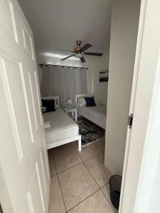 a bedroom with two beds and a ceiling fan at Tide's End in Langstrand +2 photos
