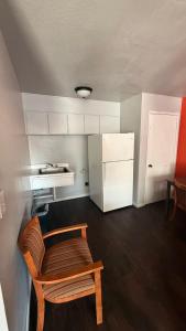 a small room with a chair and a refrigerator at The Coalinga Motel in Coalinga