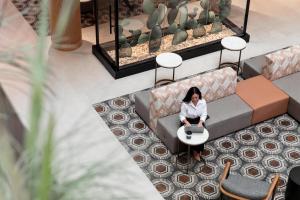 a woman sitting on a couch with a laptop at Hyatt Regency Austin in Austin +101 photos