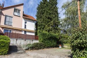 a house with a tree in front of it at Dollár Apartman in Orfű