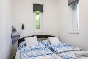 two beds in a room with two windows at Dollár Apartman in Orfű
