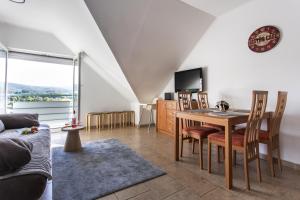 a living room with a table and chairs and a television at Dollár Apartman in Orfű