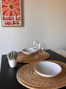 a table with two plates and wine glasses on it at Caseta Cosi in Vic-la-Gardiole
